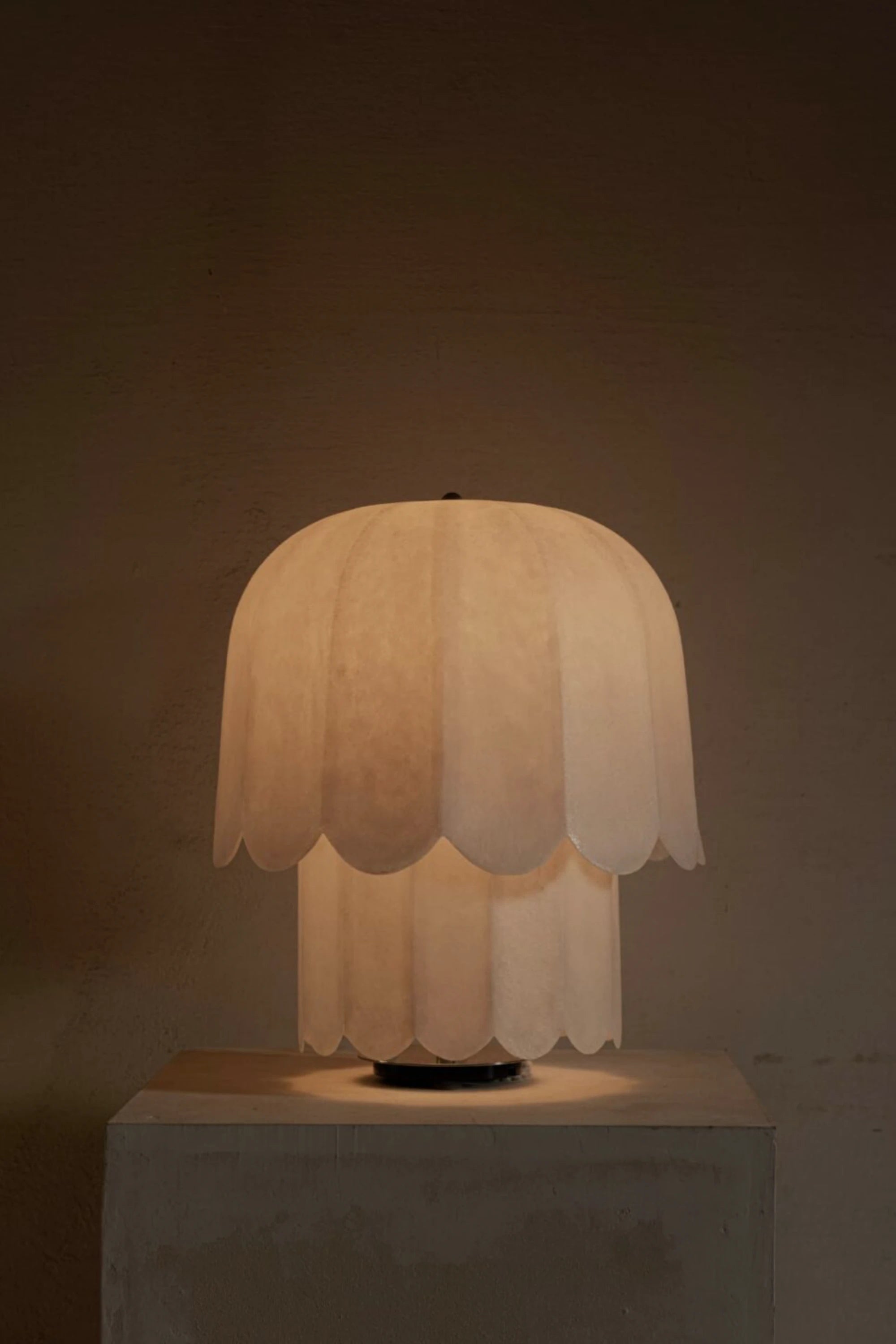 Kilzi Feather table lamp with scalloped edge shade on a dark background
