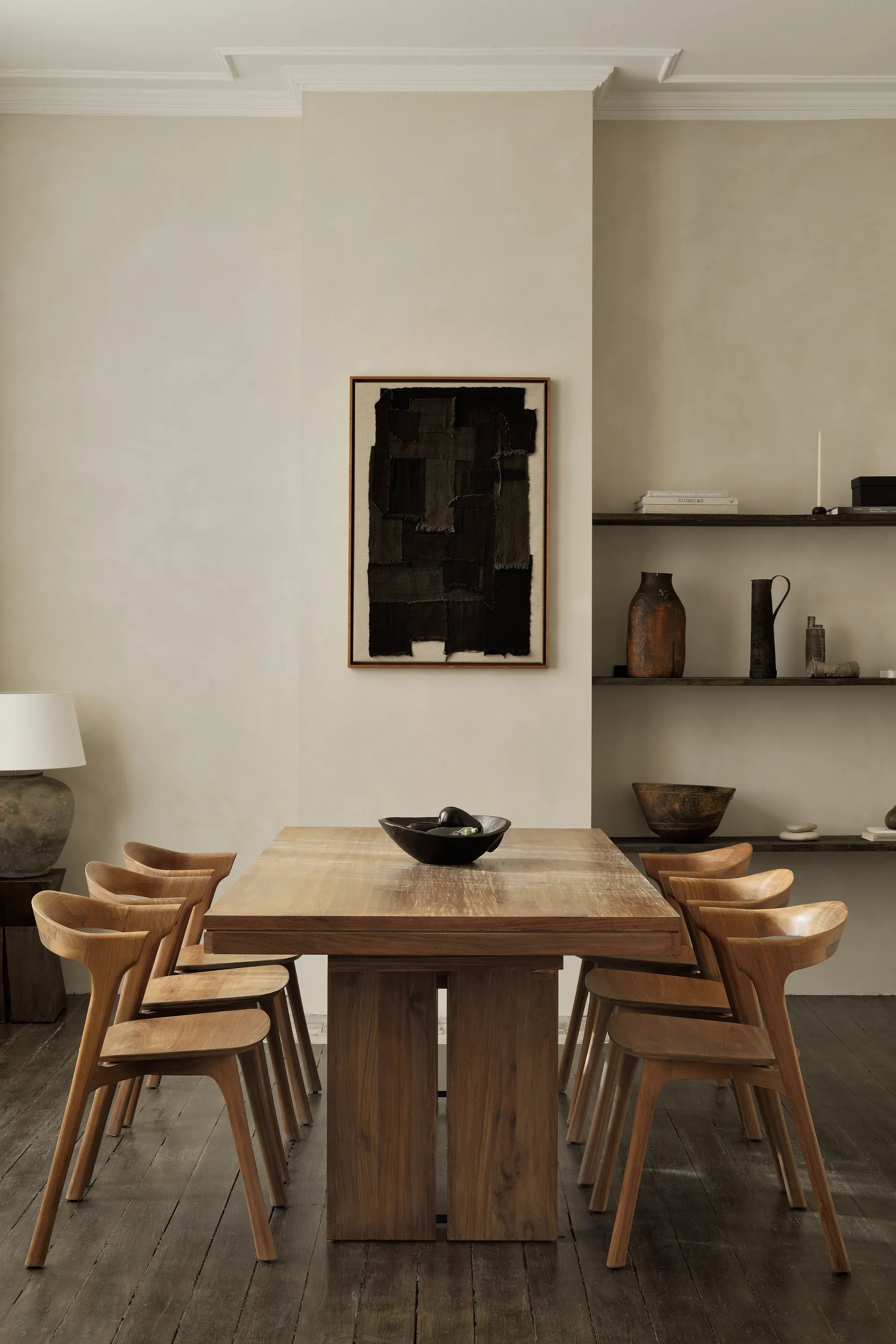 Dining room with wooden table and chairs, abstract painting on the wall.