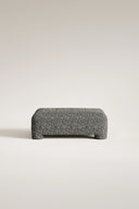 Gray textured ottoman on a light beige background