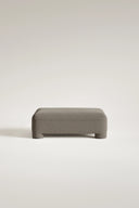 Gray upholstered bench on a light beige background