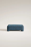 Blue ottoman on a light gray background