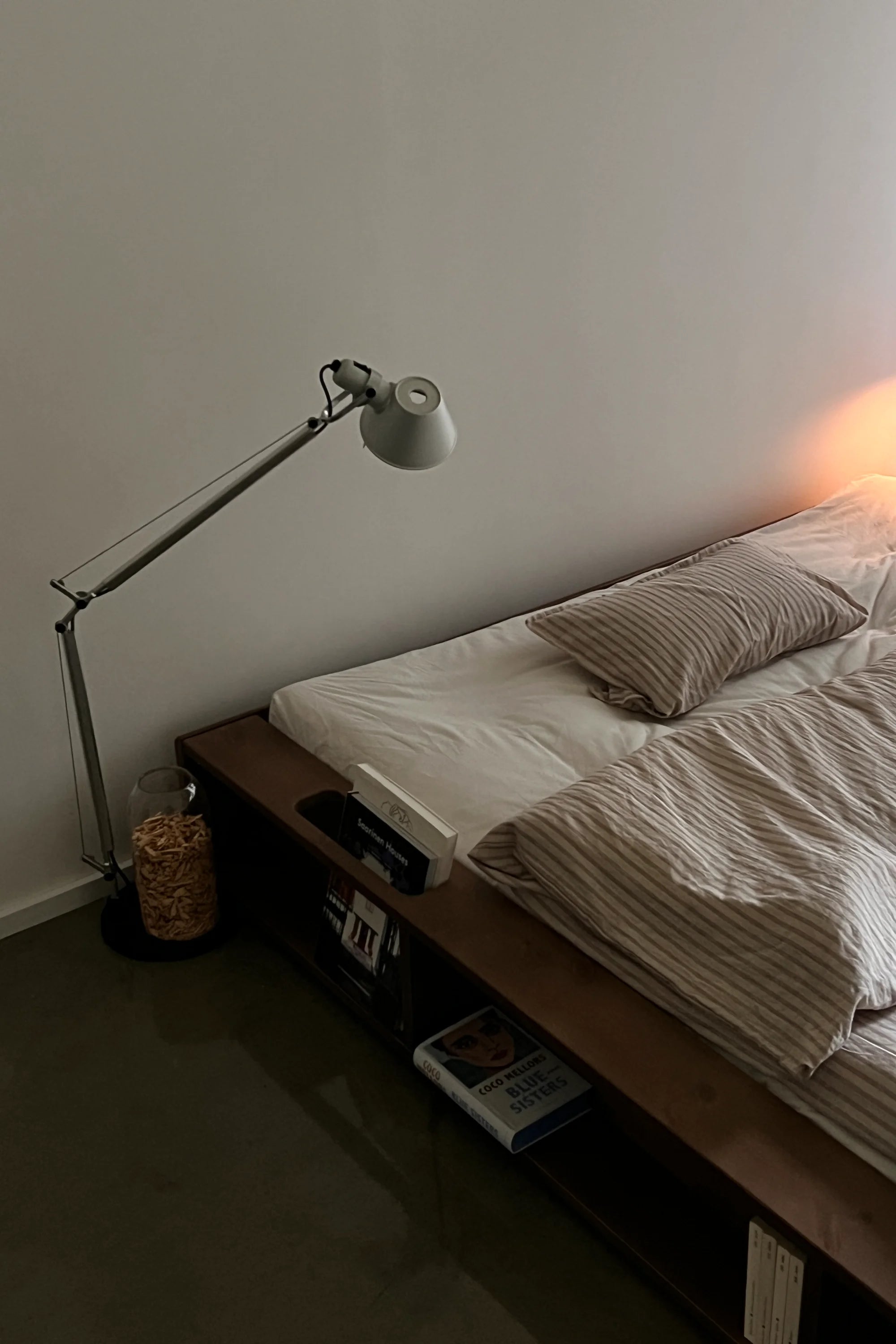 Bedroom with a bed, lamp, and small table.