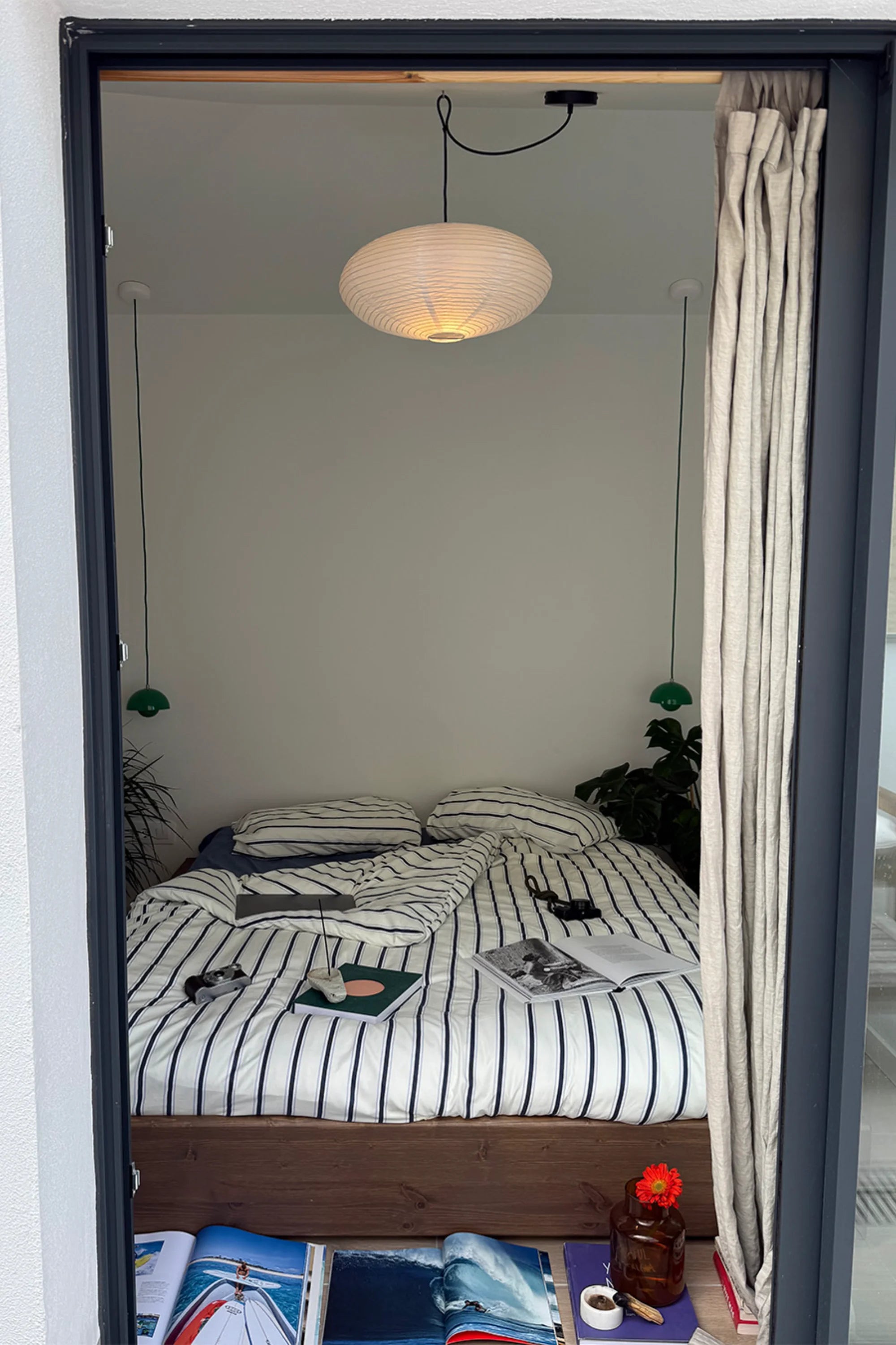 Bedroom with striped bedspread, lamp, and decor items.