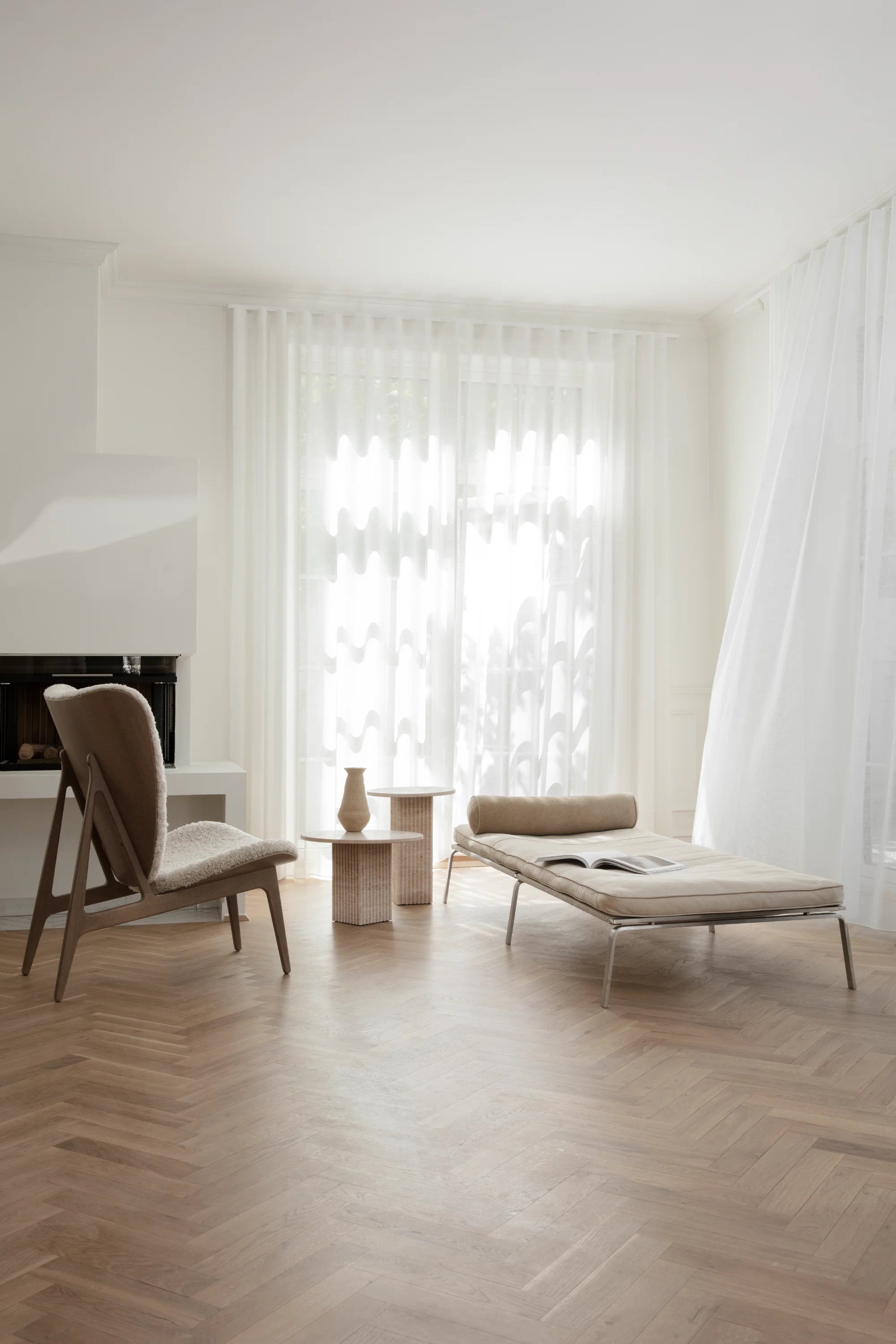 Modern living room with a chair, sofa, and coffee table on a wooden floor.