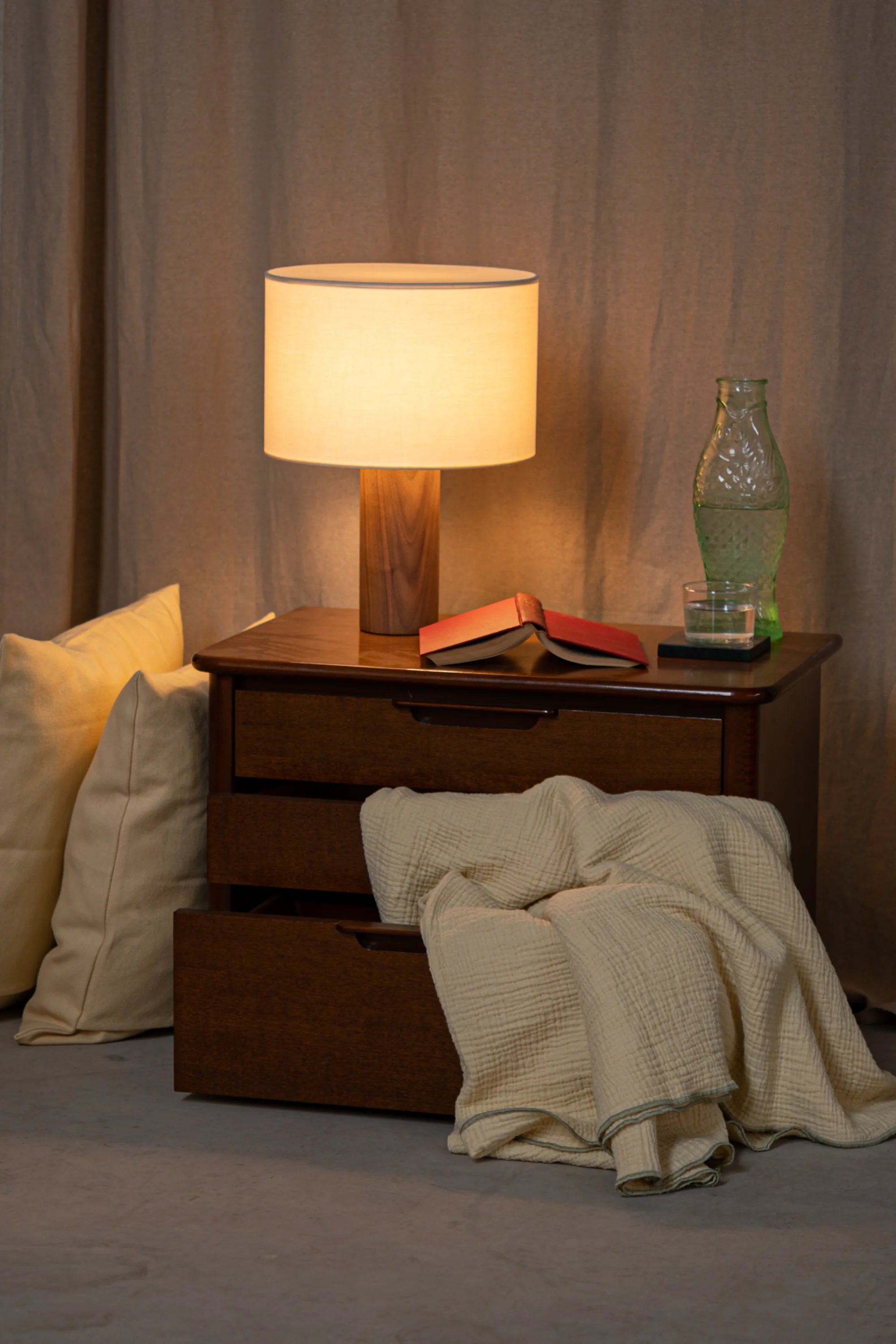 Napkin on a wooden surface with a lamp and books in the background