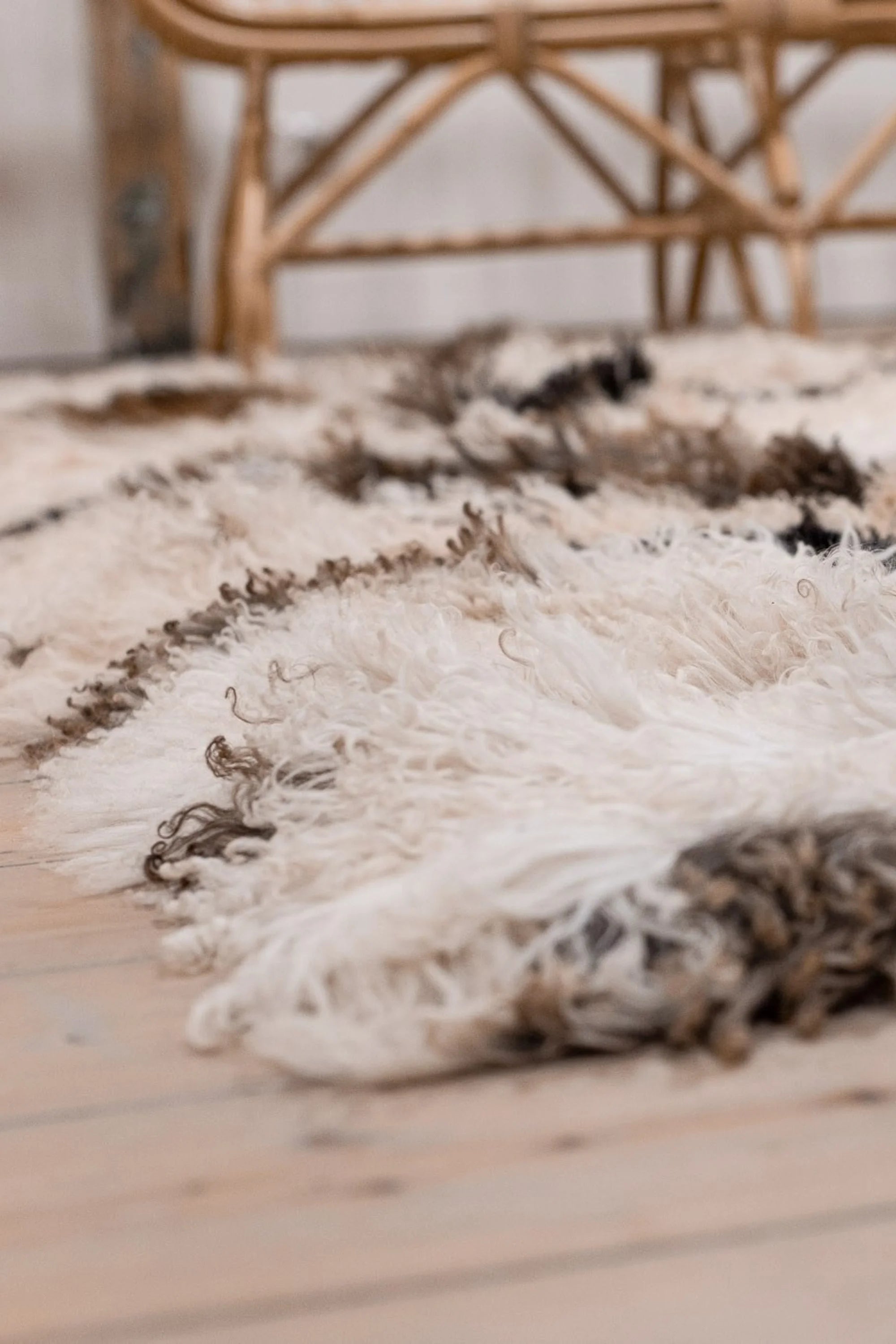 Textured white rug with brown accents on a wooden floor