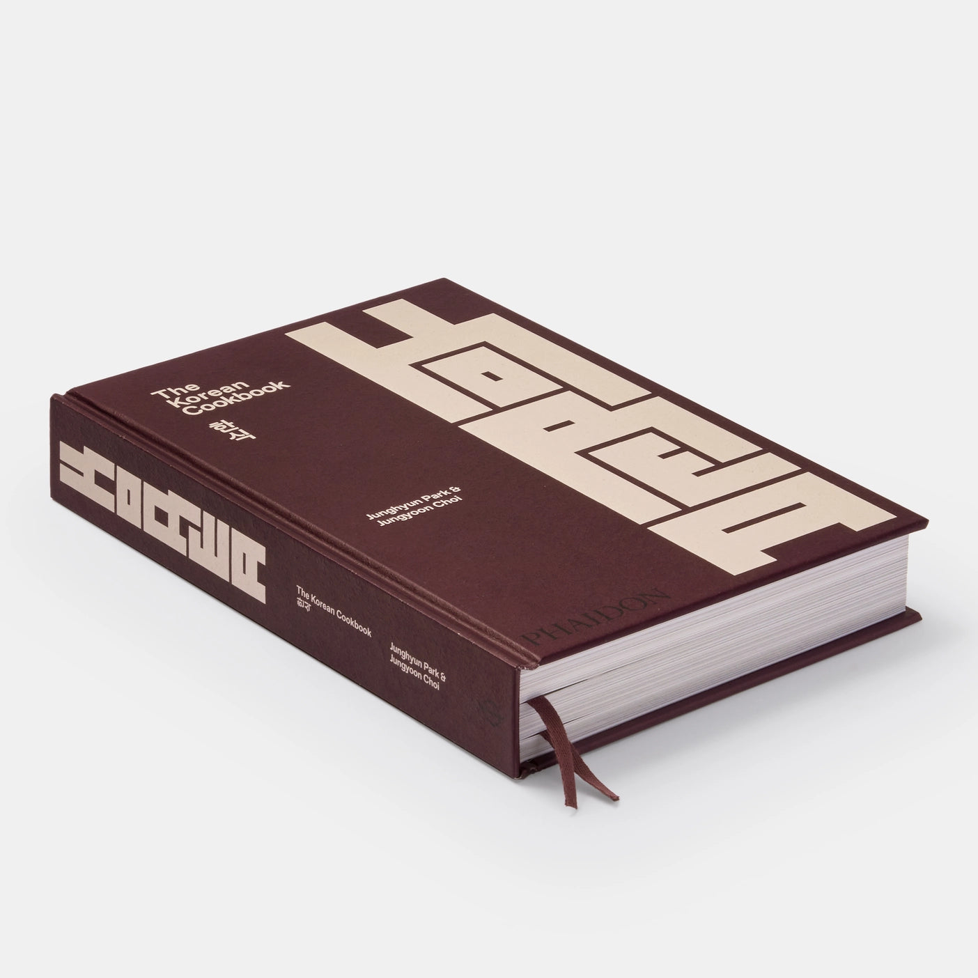The Korean Cookbook: A close-up image of the inside pages of the book with vibrant photographs of delicious Korean dishes, along with detailed instructions and cooking tips