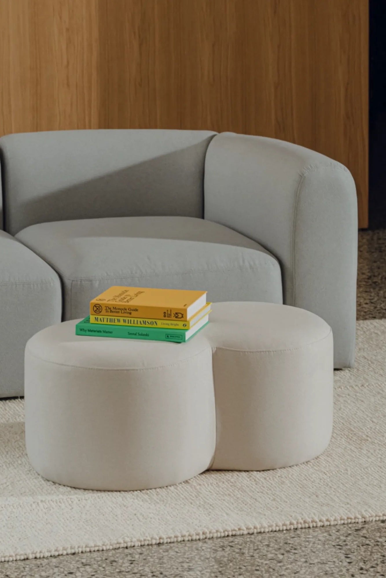 Round Umbo Pouf upholstered in gray fabric with button tufting