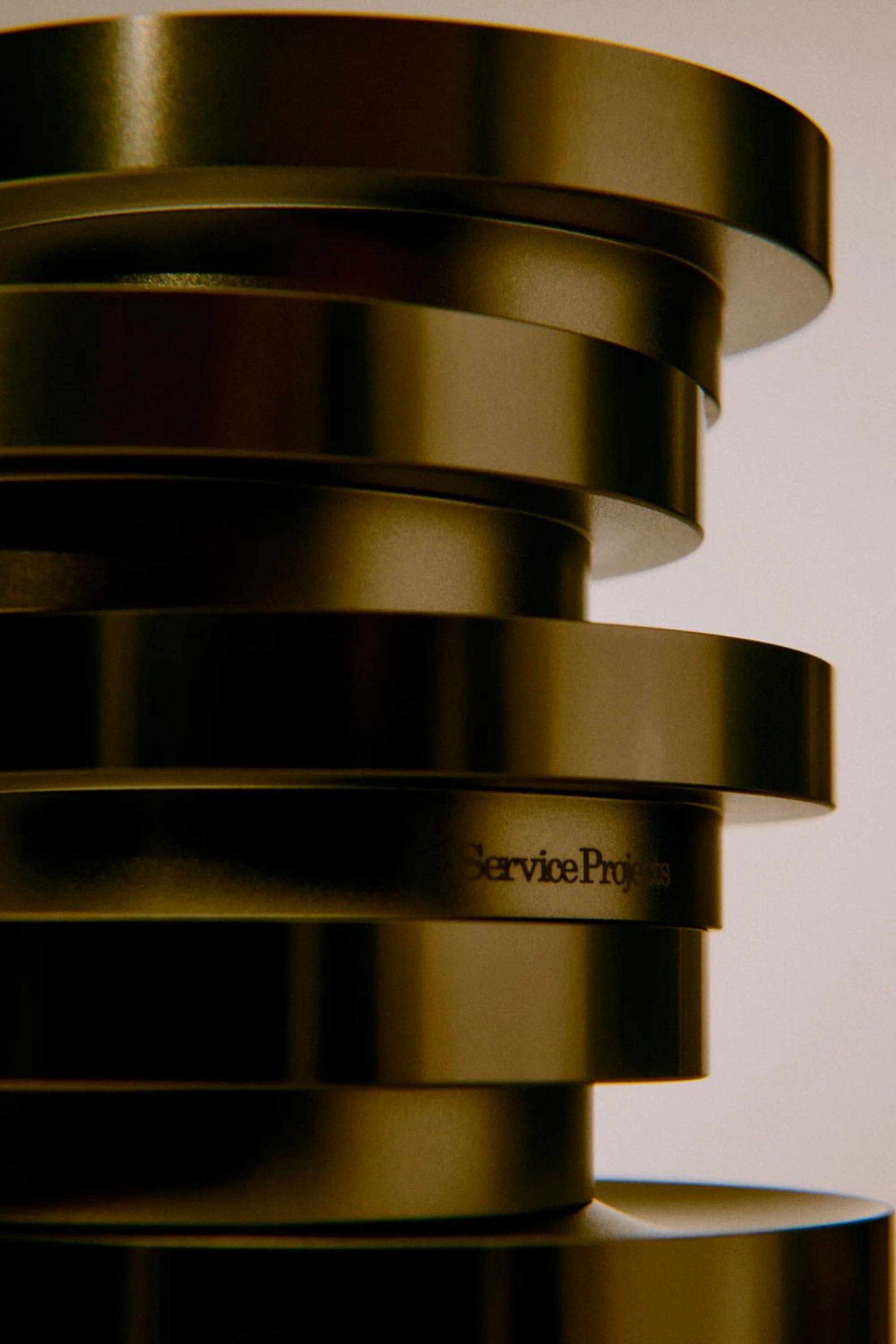 Stack of metallic egg cups with 'Service Projects' branding on a neutral background