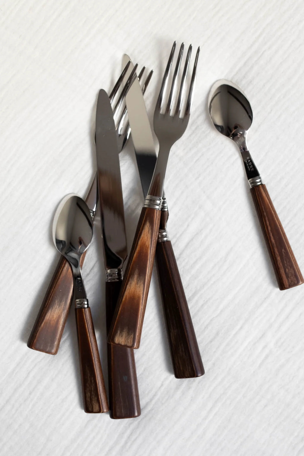 Sabre Paris Nature 5-Piece Cutlery Flatware Set, featuring polished stainless steel with elegant, dark brown wood-grain handles. This durable and stylish flatware is perfect for enhancing daily dining or special occasions for those who appreciate natural aesthetics.