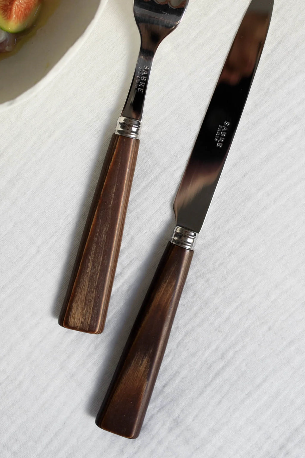 Sabre Paris Nature 5-Piece Cutlery Flatware Set, featuring durable stainless steel with elegant, dark brown wood-grain handles and polished silver bands. This stylish set is perfect for enhancing everyday dining or special occasions for those who appreciate natural aesthetics.