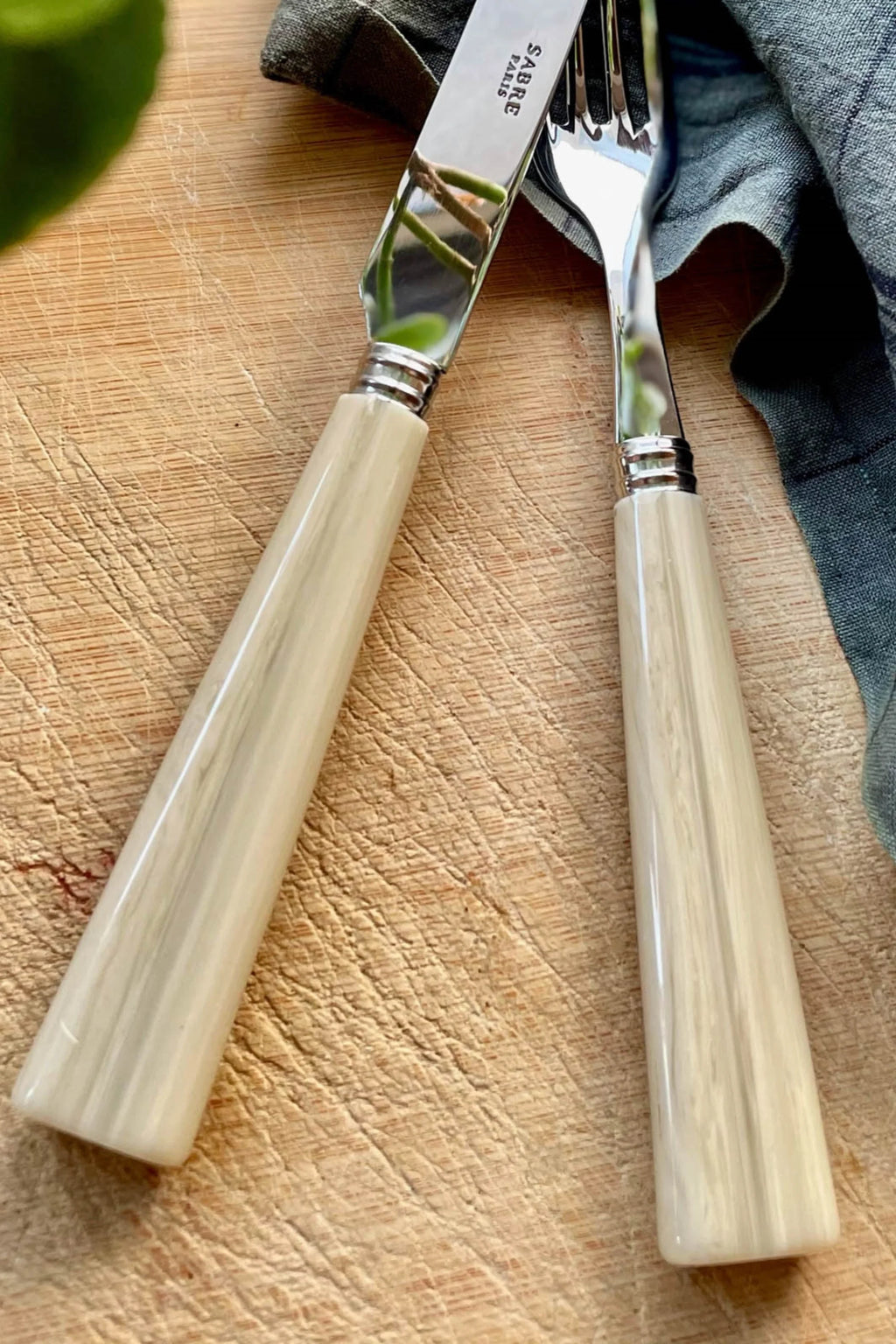 Sabre Paris Nature 5-Piece Cutlery Flatware Set, featuring polished stainless steel with elegant, light cream-colored handles mimicking natural horn. This stylish and durable flatware is perfect for enhancing everyday dining or special occasions for design-conscious individuals.