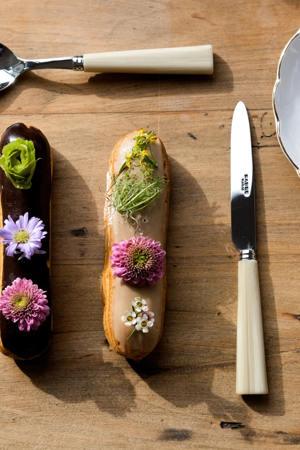 Sabre Paris Nature 5-Piece Cutlery Flatware Set, featuring a polished stainless steel spoon and knife with elegant cream-colored, ridged handles and silver ferrules. This stylish and durable flatware is perfect for adding a touch of natural sophistication to any modern dining table or special occasion.
