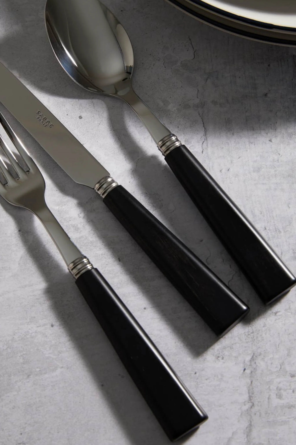 Sabre Paris Nature 5-Piece Cutlery Flatware Set, featuring sleek polished stainless steel and elegant black resin handles with ridged silver collars. This stylish and durable flatware is perfect for enhancing modern dining experiences for discerning hosts.