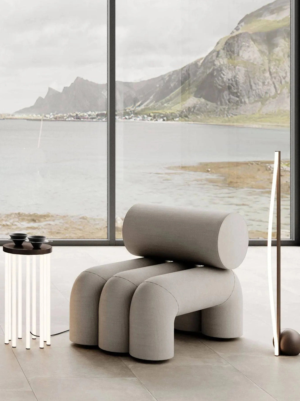 101 CPH Foku Lounge Chair in a modern light grey fabric, featuring a unique, plush cylindrical backrest and three curved, pipe-like legs. A luxury statement piece for contemporary living spaces.