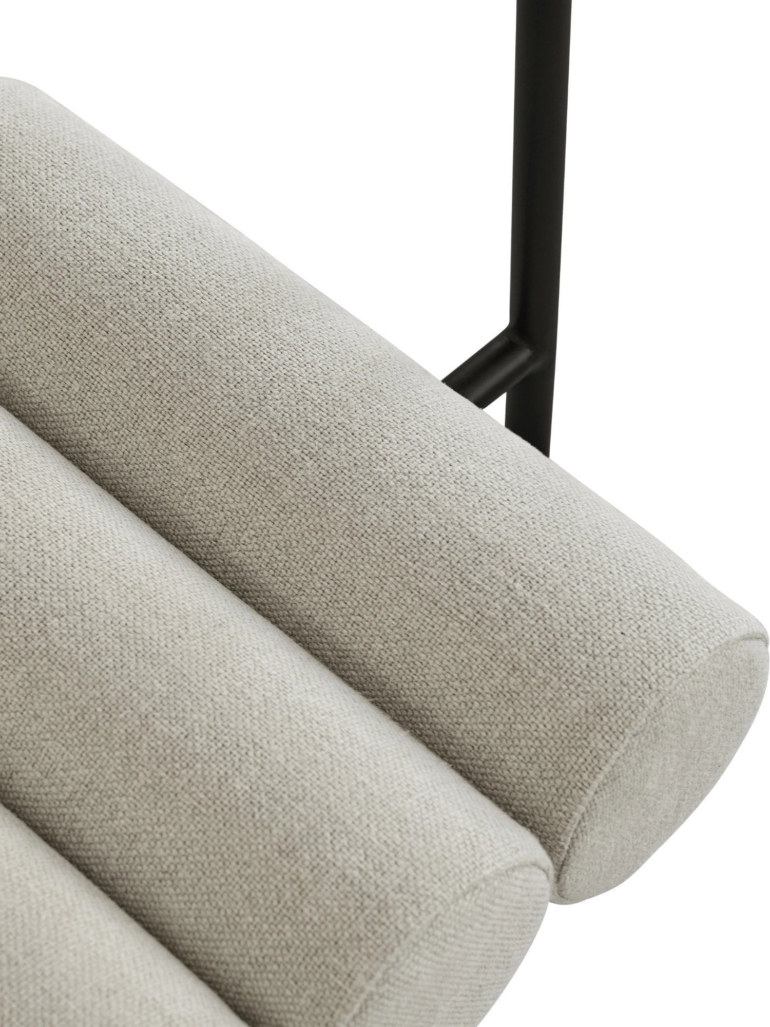 101 CPH Hiro Dining Chair close-up showing light beige textured fabric upholstery on three distinct padded rolls and a partial view of a sleek black metal frame. This unique designer chair adds a stylish touch to any modern interior.