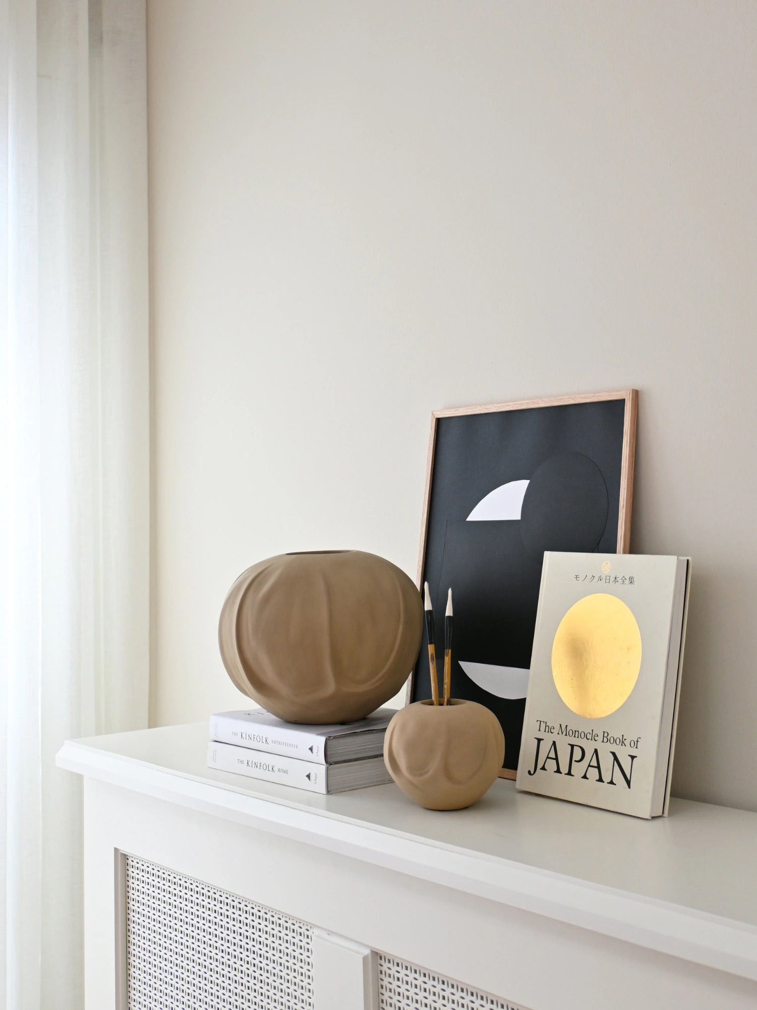 101 CPH Orimono Vase in a natural taupe finish with organic, ribbed indentations, displayed as a decorative accent on a white console table. Ideal for adding a touch of minimalist design.