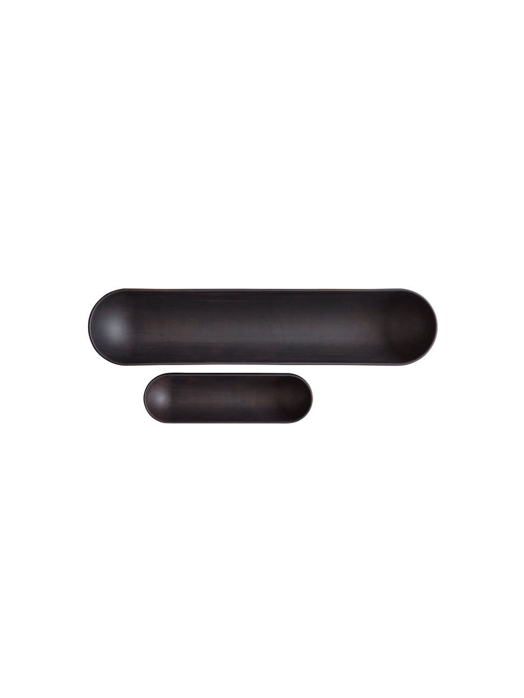 101 CPH Shinju Tray. Two elongated, capsule-shaped matte dark brown or black ceramic trays, one larger and one smaller, artfully arranged on a white background. Perfect for modern home decor.
