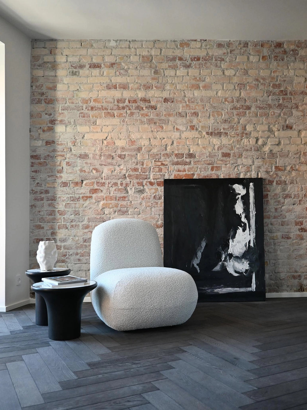 101 CPH Trumpet Side Table in a lifestyle setting, showcasing two black stoneware modern side tables with white marble-effect tops. A premium, curvy sofa and abstract art are visible. Ideal for contemporary living spaces.