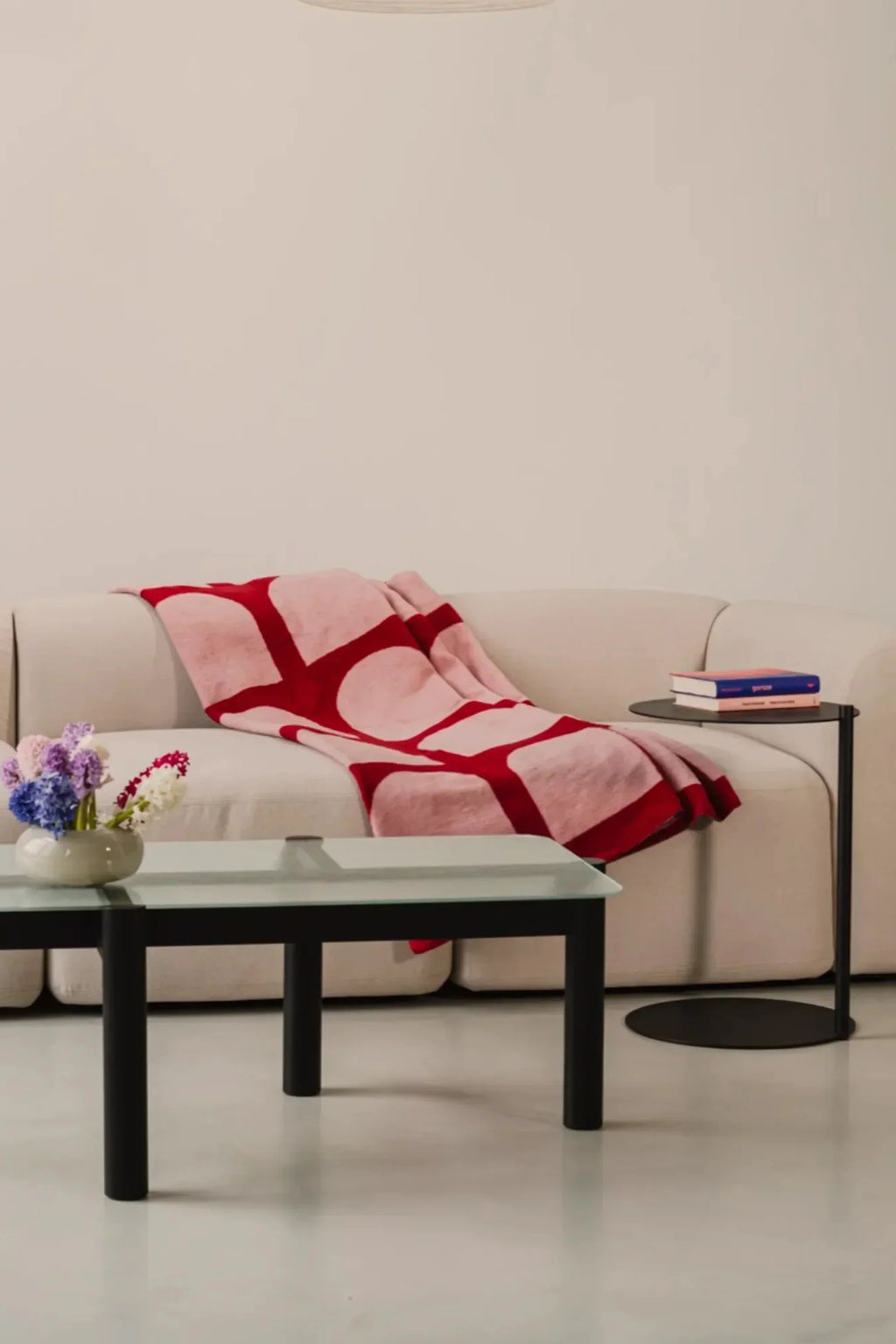 noo.ma Flom 2-Seater Sofa, a modern minimalist sofa upholstered in a soft, plush cream fabric, featuring gently curved arms, a low profile, and clean, organic lines. This contemporary compact sofa is perfect for small apartment living rooms or adding Scandinavian comfort to minimalist interiors.
