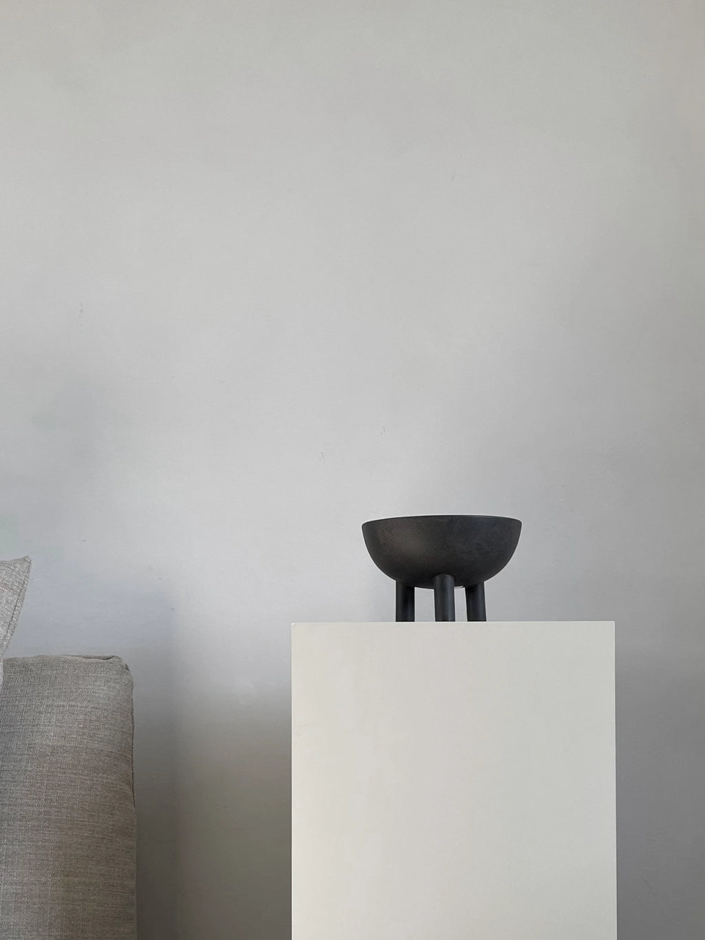 101 CPH Duck Bowl, a unique black ceramic bowl with three stout legs, displayed on a minimalist white pedestal. This premium decorative object adds modern sophistication to any space.