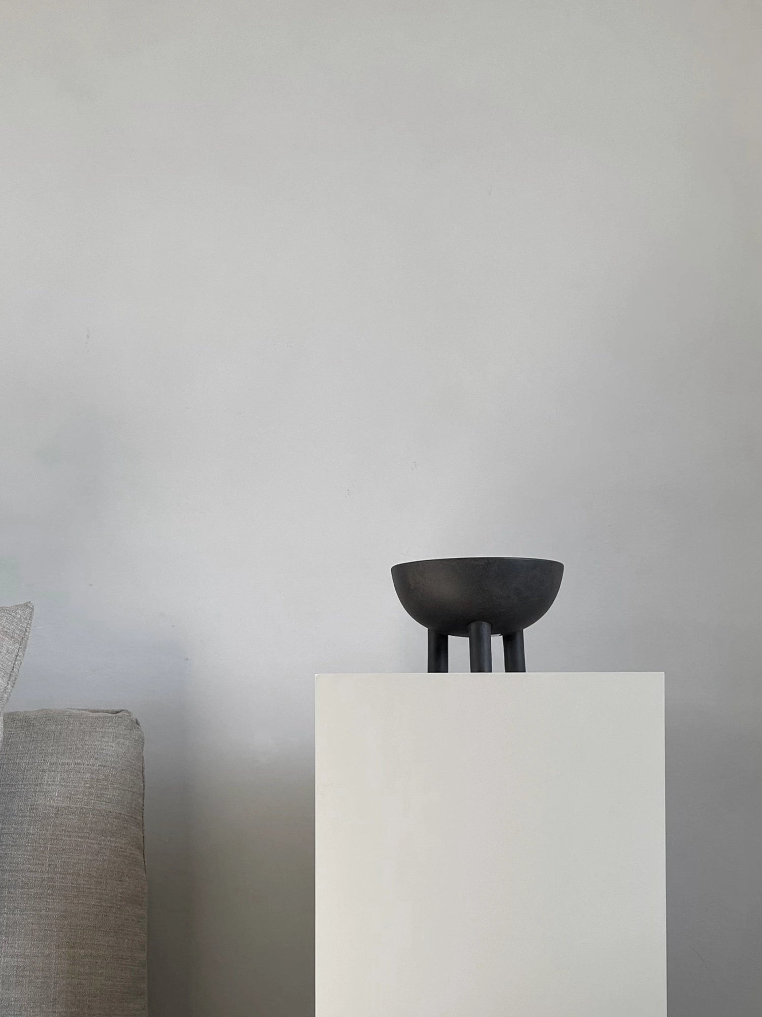 101 CPH Duck Bowl, a unique black ceramic bowl with three stout legs, displayed on a minimalist white pedestal. This premium decorative object adds modern sophistication to any space.