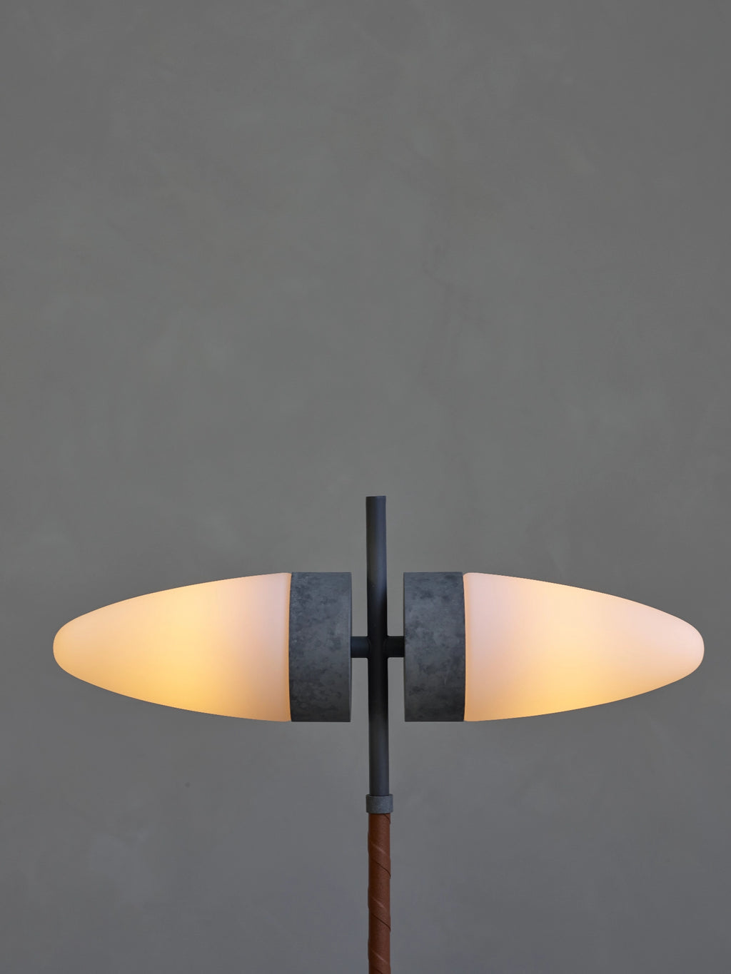 101 CPH Bull Floor Lamp shows two glowing oval frosted glass shades, a dark metal frame, and a rich brown leather-wrapped stem. This luxury contemporary lighting piece is perfect for ambient room illumination.