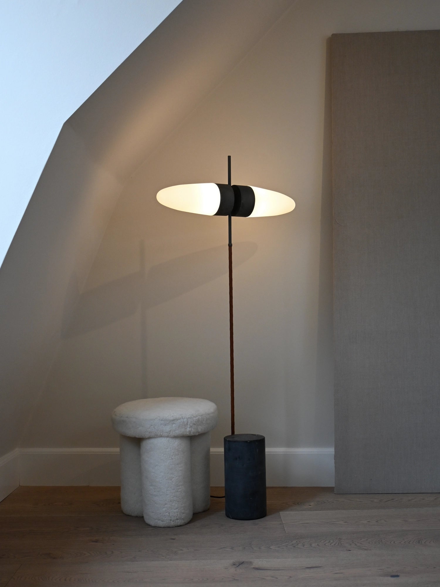 101 CPH Bull Floor Lamp in a luxurious lifestyle setting, featuring a sleek brown pole, black fixture, and two glowing white oval shades on a concrete base. Perfect for modern interior design.
