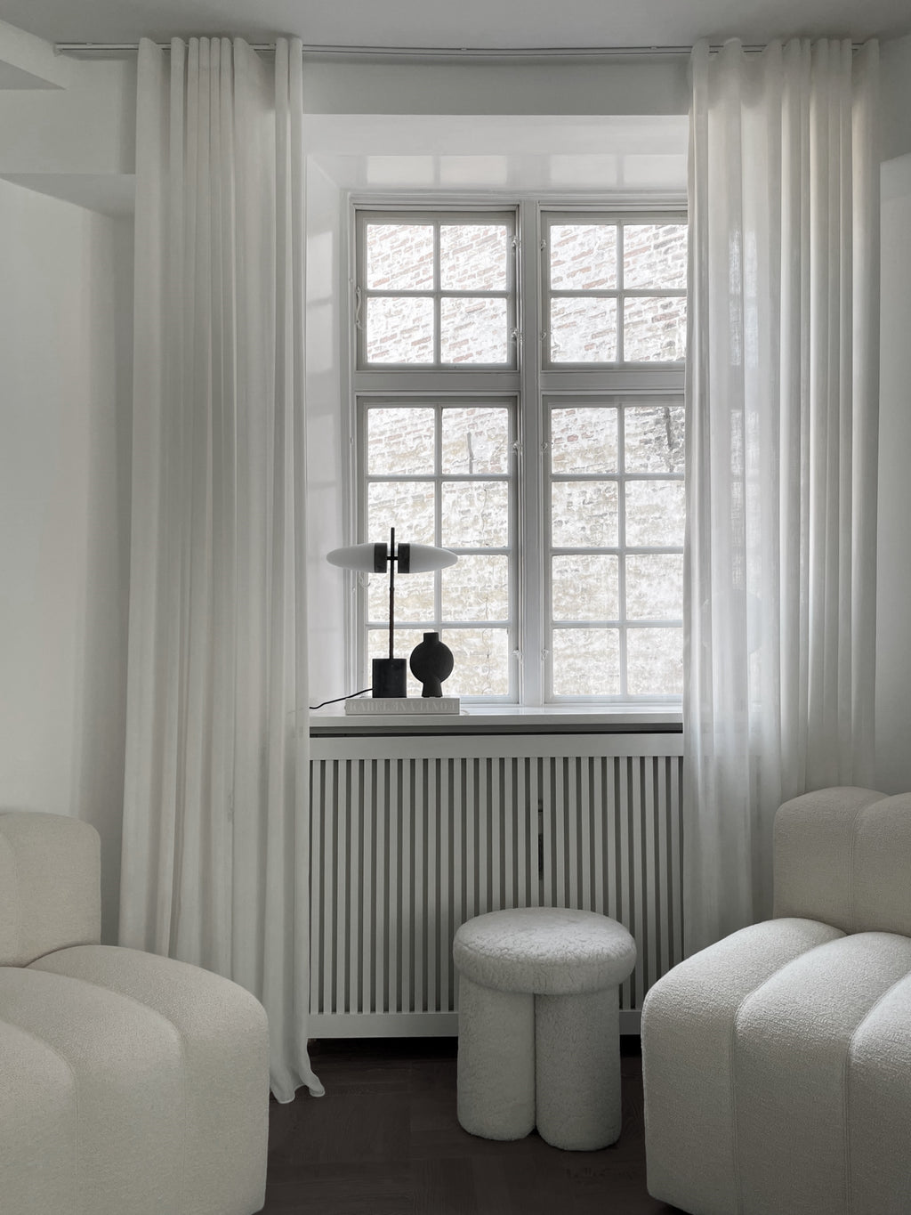 101 CPH Bull Table Lamp with white elliptical shades and a dark metal/marble base, styled on a window sill with minimal decor. A premium modern lighting piece for contemporary interiors.