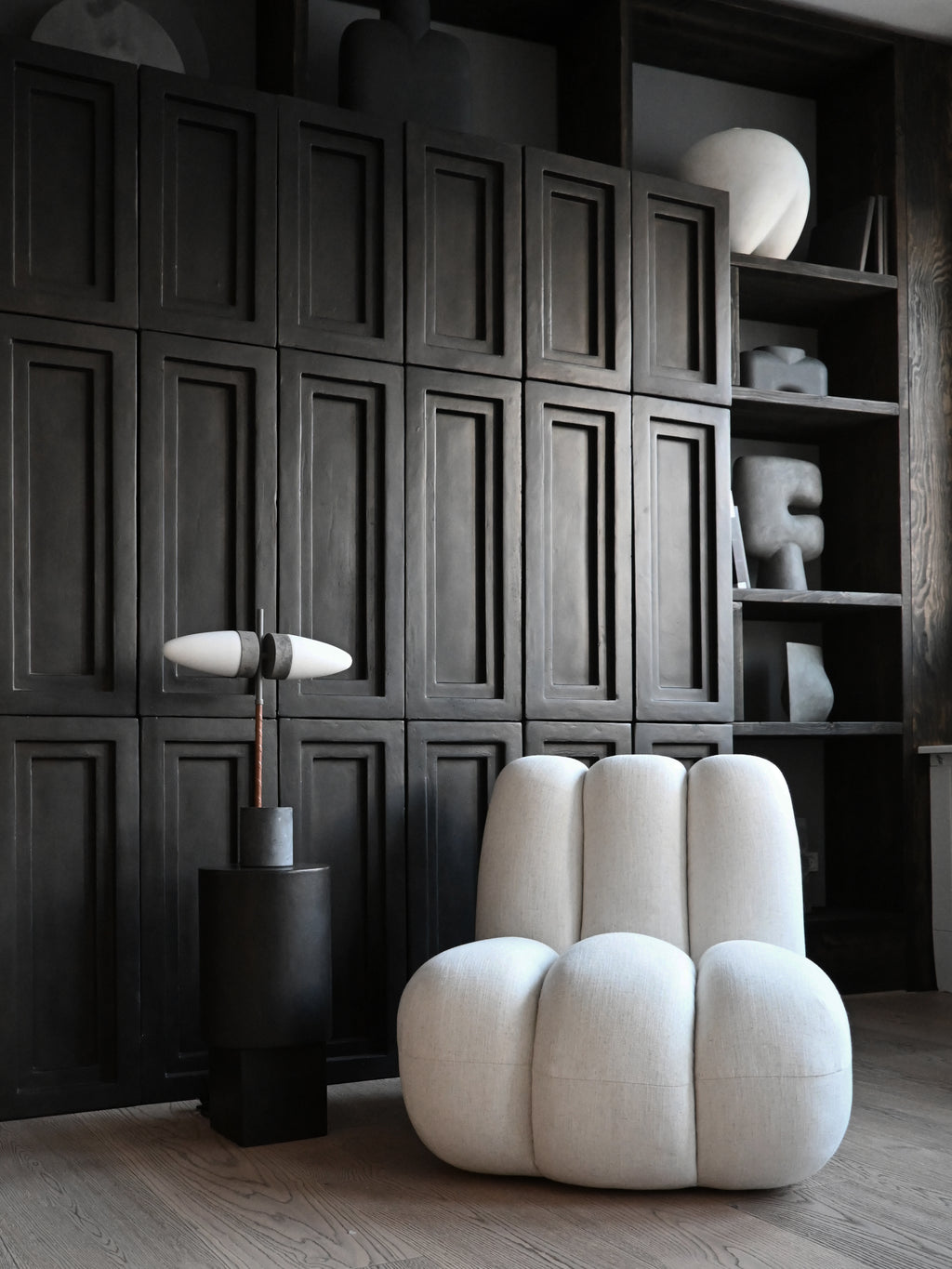 101 CPH Bull Table Lamp, a luxury piece featuring twin white oval diffusers, a copper wrapped stem, and a concrete base, displayed on a black cylindrical stand. Perfect for sophisticated modern interiors.