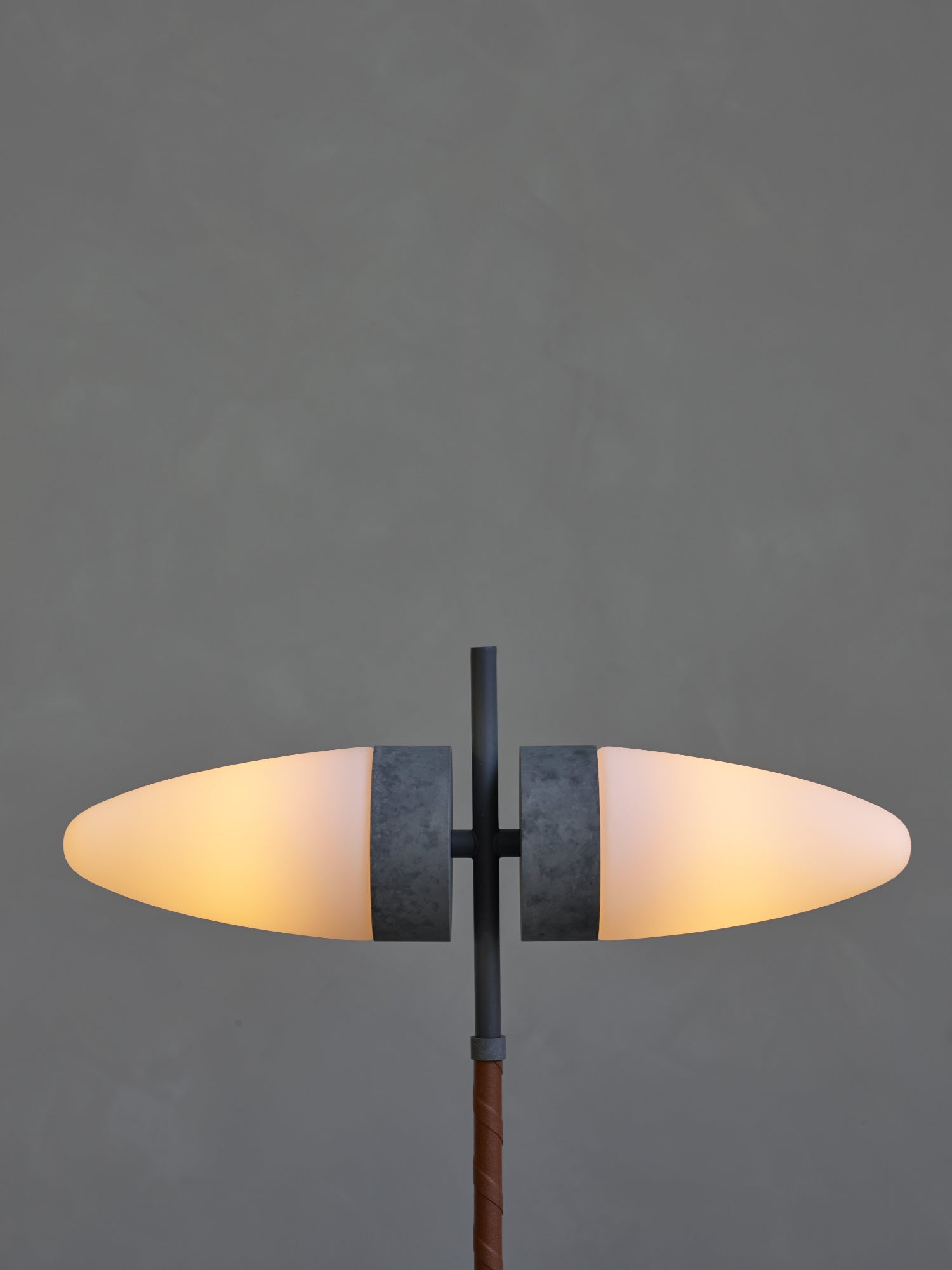 101 CPH Bull Table Lamp features glowing warm white oval frosted glass shades, a dark gray metal stem, and a wrapped genuine leather detail. A premium modern lighting design.