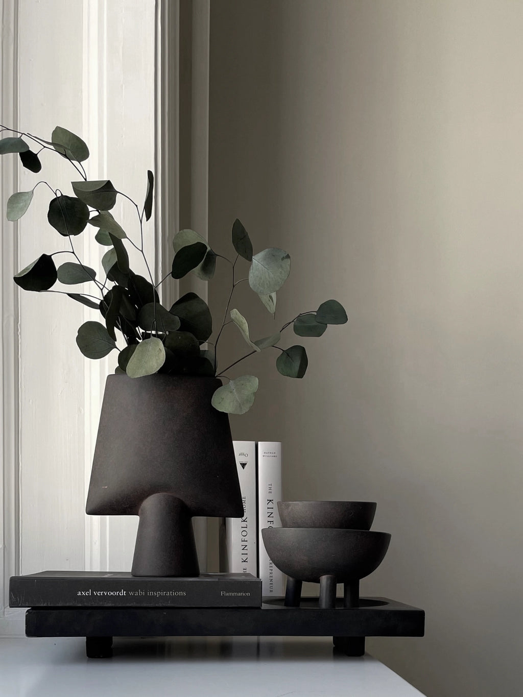 101 CPH Duck Bowl. Two handcrafted dark gray ceramic footed bowls with a textured matte finish, one stacked on the other, displayed as a luxury home decor accent. Ideal for minimalist modern interiors.