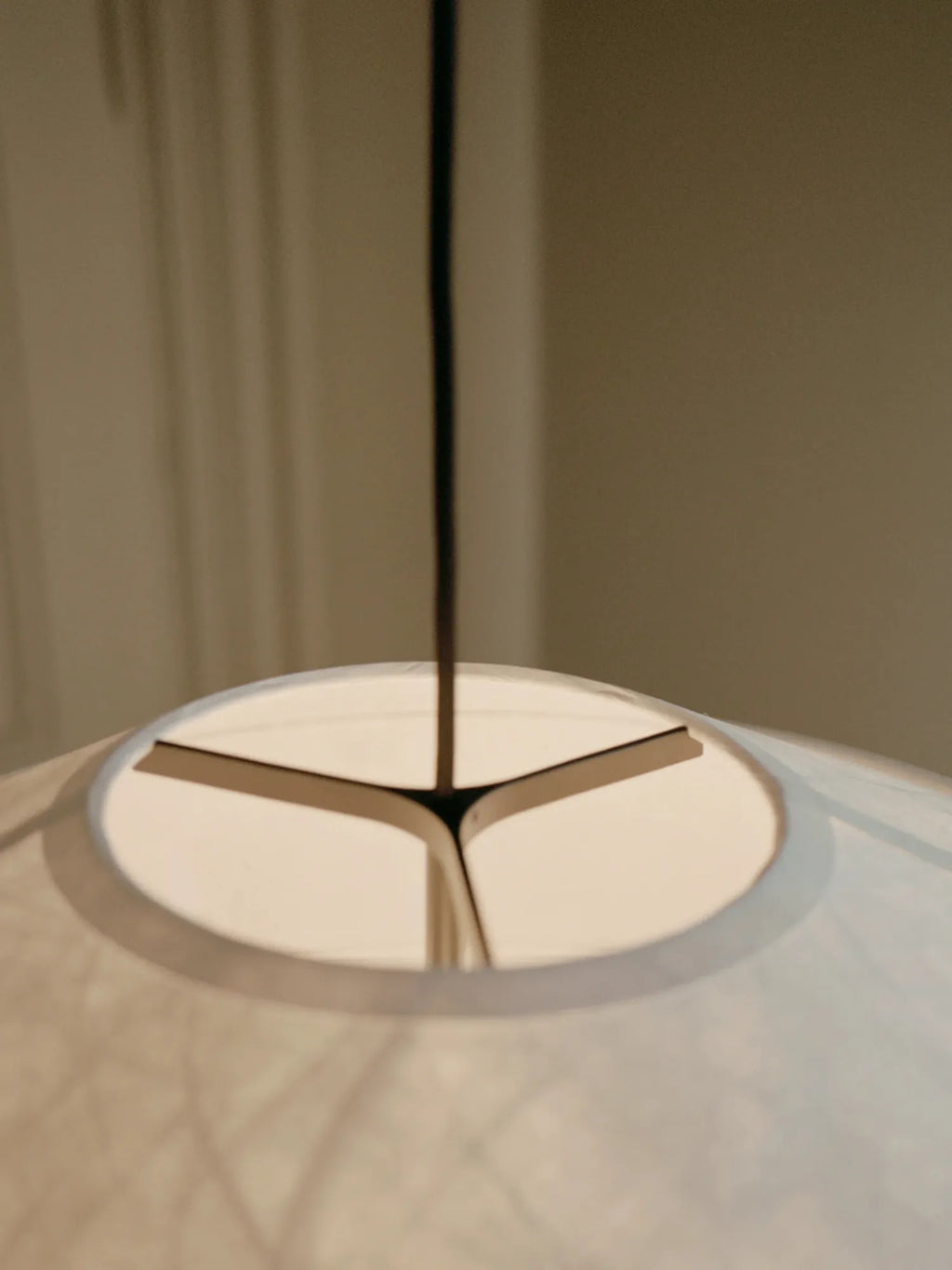 New Works Kite Pendant Lamp close-up, revealing the textured white paper shade with intricate folds and black internal metal support structure. A premium, modern lighting fixture.