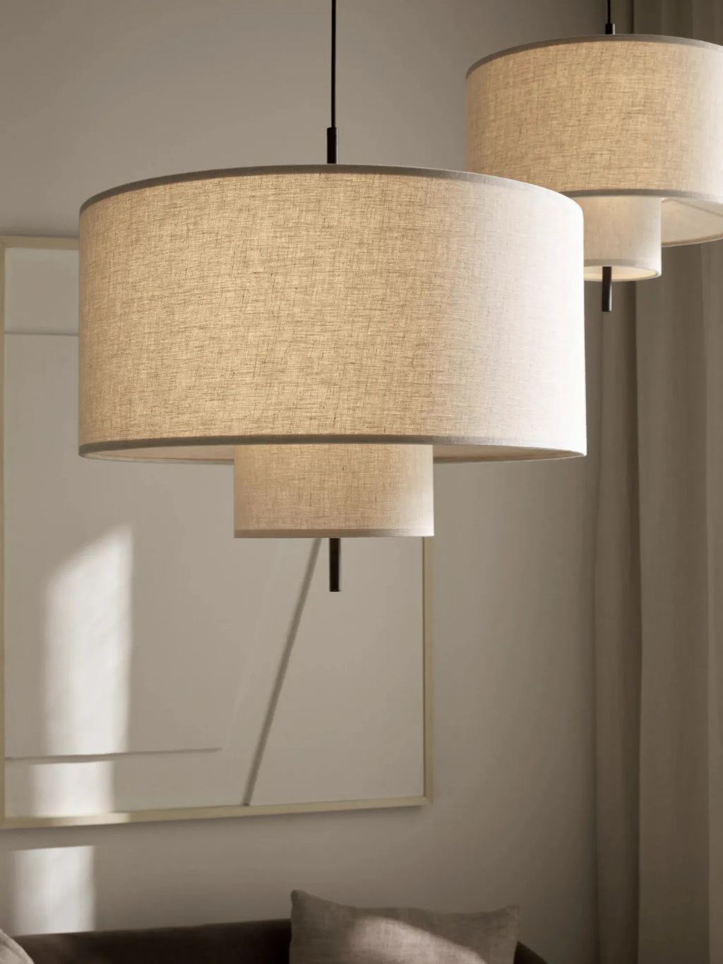 New Works Margin Pendant Lamp, featuring two layered round linen fabric shades in a light beige with grey trim, providing a warm, diffused glow. A premium lighting solution for modern interiors.