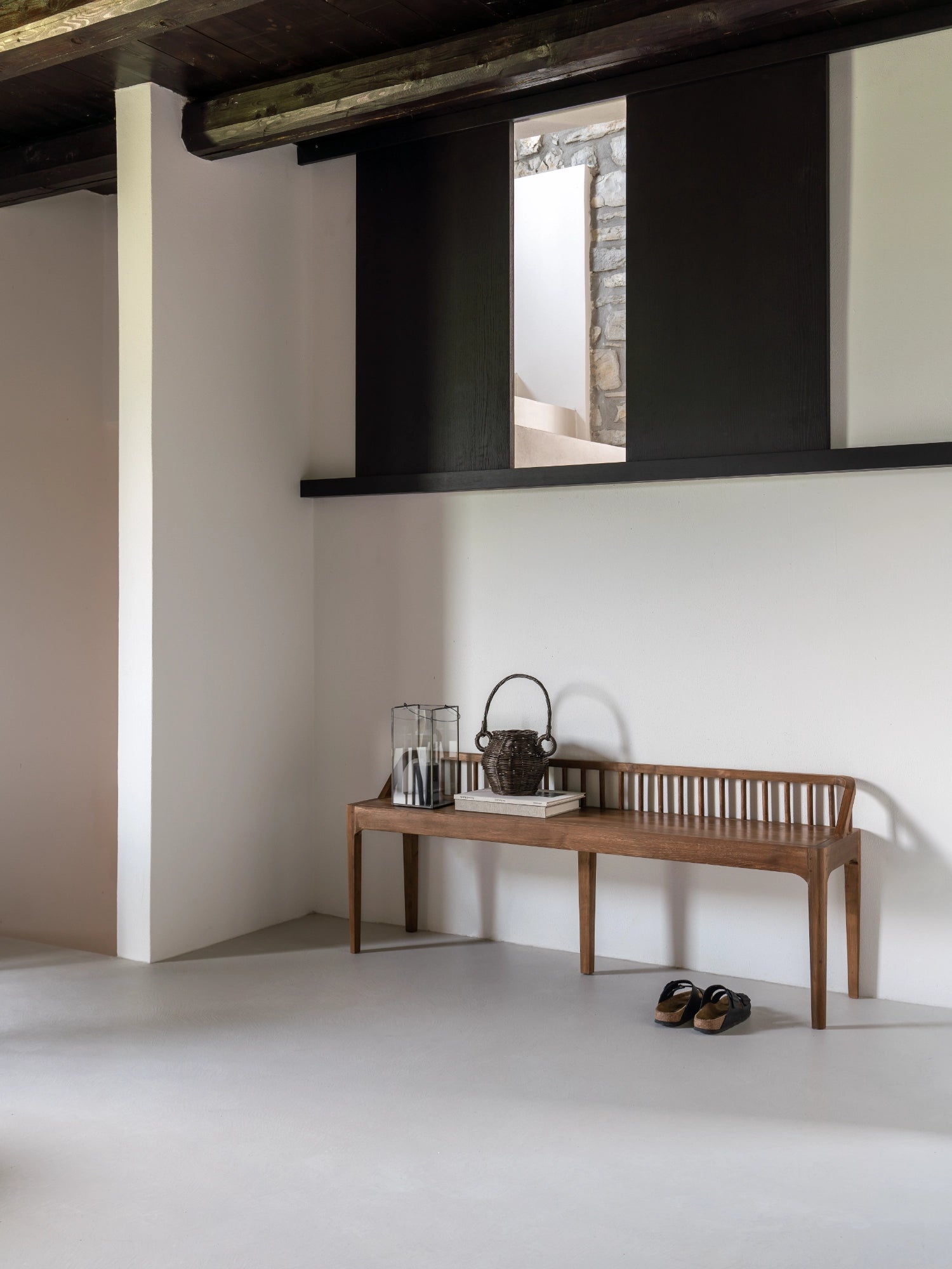 Ethnicraft Spindle Bench, a modern minimalist solid teak wood bench featuring a distinctive slatted spindle backrest and gently curved armrests, crafted with clean lines and a warm natural brown finish. Its elegant tapered legs provide a light, sophisticated profile. Perfect for a Scandinavian entryway, contemporary dining room, or as a stylish bedroom accent.