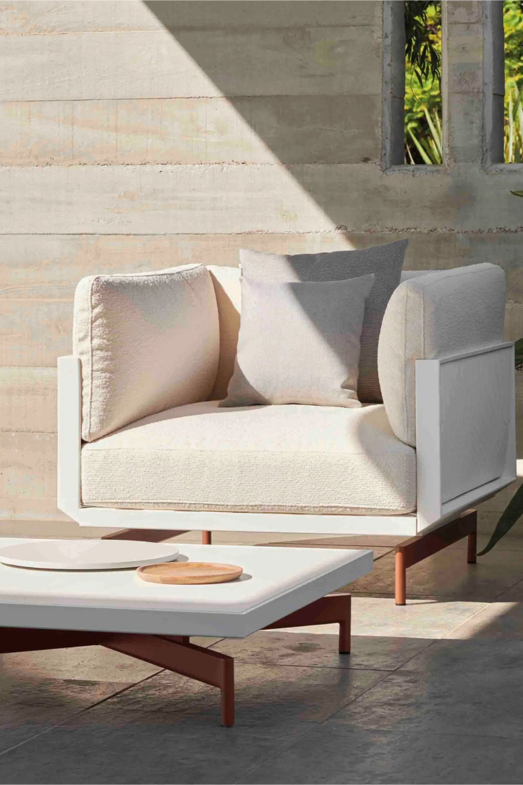 Gandia Blasco Onde Lounge Chair, a modern minimalist outdoor armchair featuring a crisp white aluminum frame and plush, textured off-white outdoor fabric cushions with coordinating light grey accent pillows.