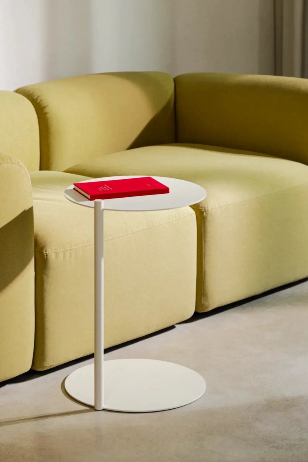 noo.ma Flom 2-Seater Sofa, a contemporary minimalist sofa upholstered in a soft pale olive green textured fabric with a gently curved, low-profile design and plush rounded edges.