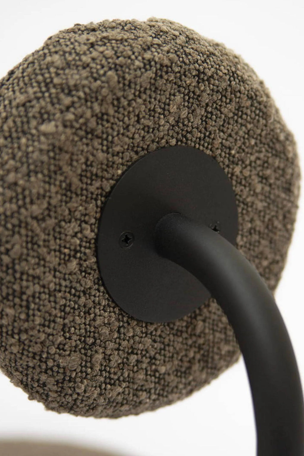 NG DESIGN Object 077 Chair, featuring a distinctive round, plush upholstered component in a rich, textured brown bouclé fabric with a nubbly finish, connected by a sleek matte black metal curved frame. This contemporary accent chair, with its organic modern aesthetic, is ideal for adding tactile warmth and a stylish statement to minimalist living rooms or bedrooms.