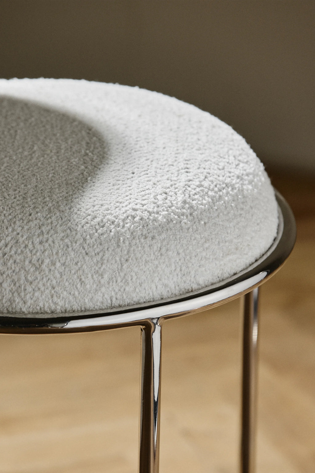 Nordal Komati Stool, a modern minimalist round accent stool featuring a plush cream-colored bouclé fabric upholstered seat with a soft, textured finish, set upon a sleek, polished chrome metal frame with slender cylindrical legs. This contemporary stool is perfect for Scandinavian living rooms, a chic bedroom vanity, or as stylish entryway seating.