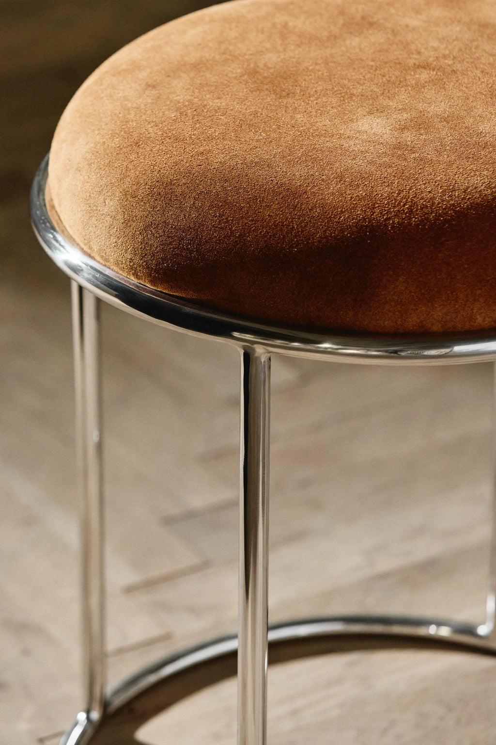 Nordal Komati Stool, a modern minimalist accent stool with a comfortable round seat upholstered in warm tan suede, set on a sleek chrome-plated tubular steel frame.