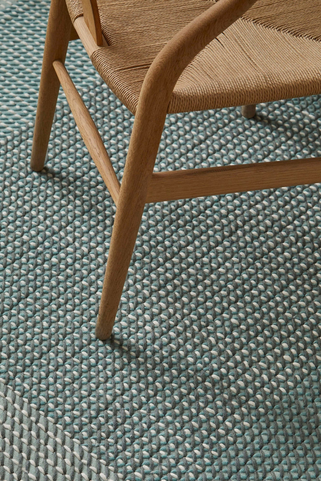 GAN Rugs Canevas Geo Rug, a contemporary hand-knotted wool area rug featuring a vibrant teal base with a distinctive geometric pattern of plush grey and white woven loops.