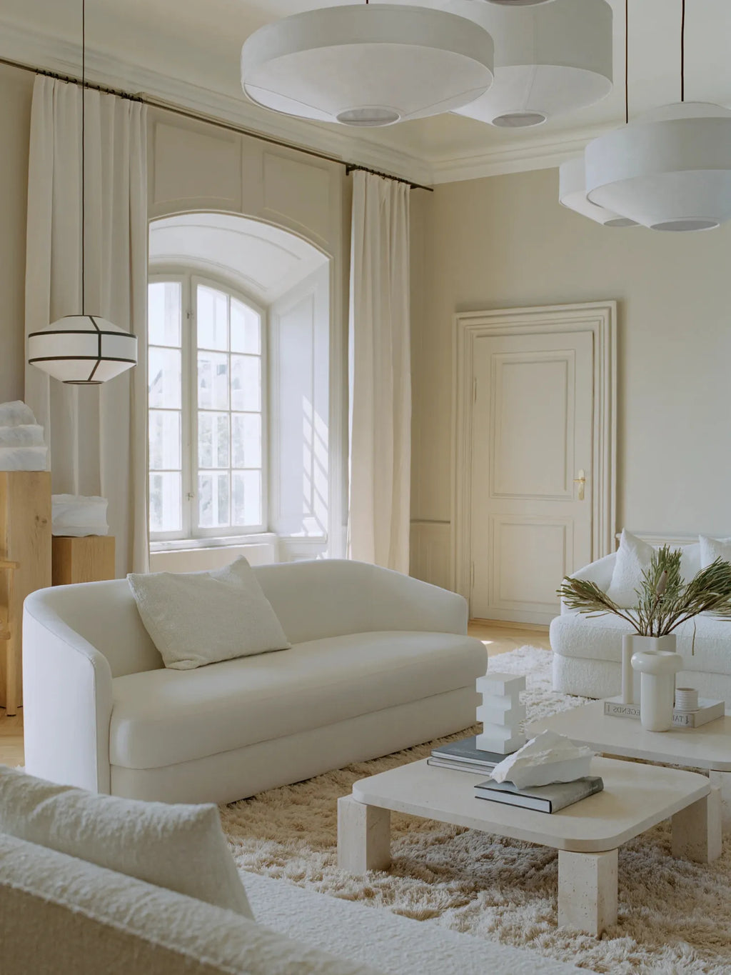 New Works Kite Pendant Lamp; a modern white fabric lampshade with a black geometric frame, hanging elegantly in a luxurious, bright living room. Ideal for contemporary interior design.