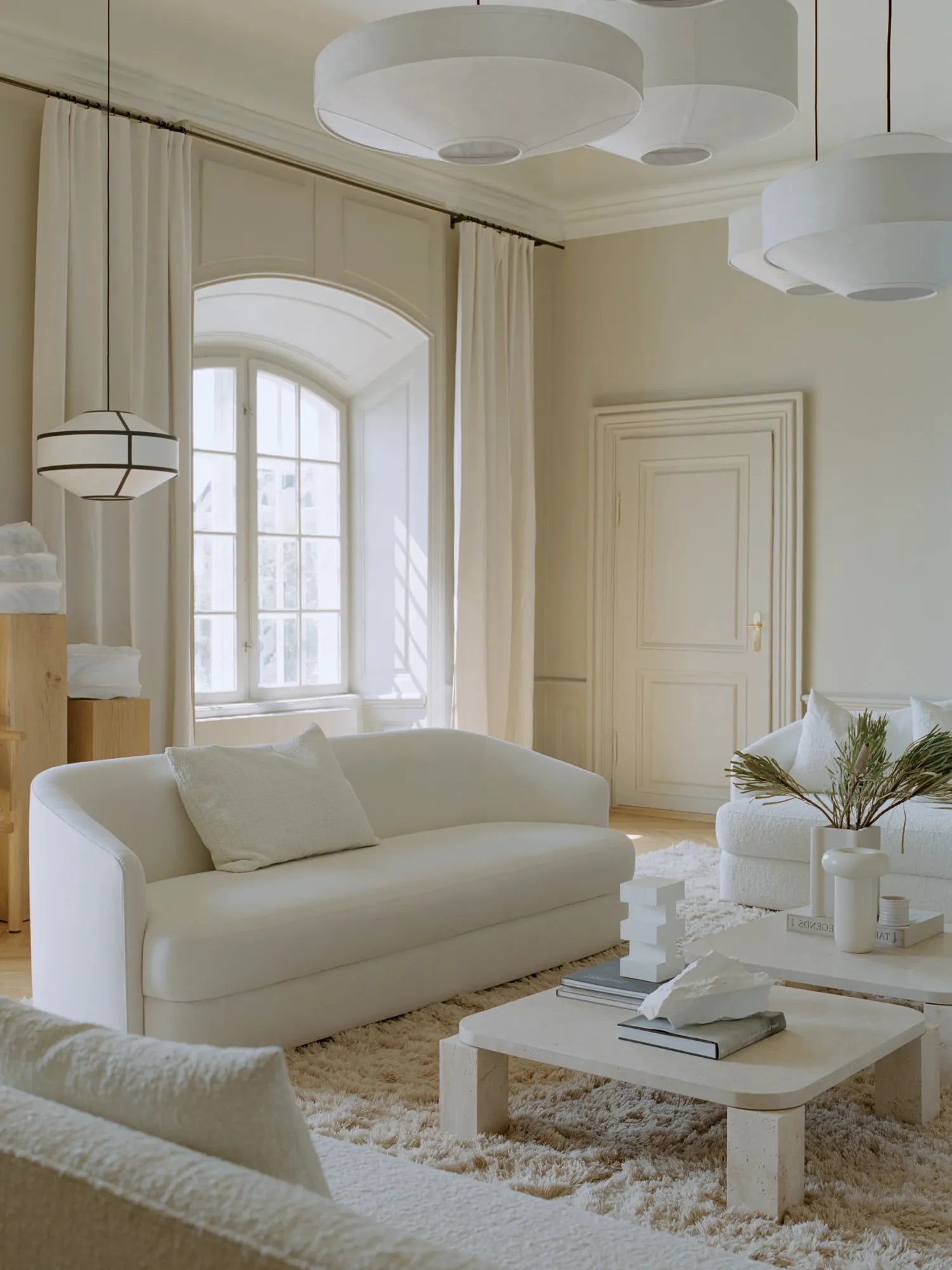 New Works Kite Pendant Lamp; a modern white fabric lampshade with a black geometric frame, hanging elegantly in a luxurious, bright living room. Ideal for contemporary interior design.