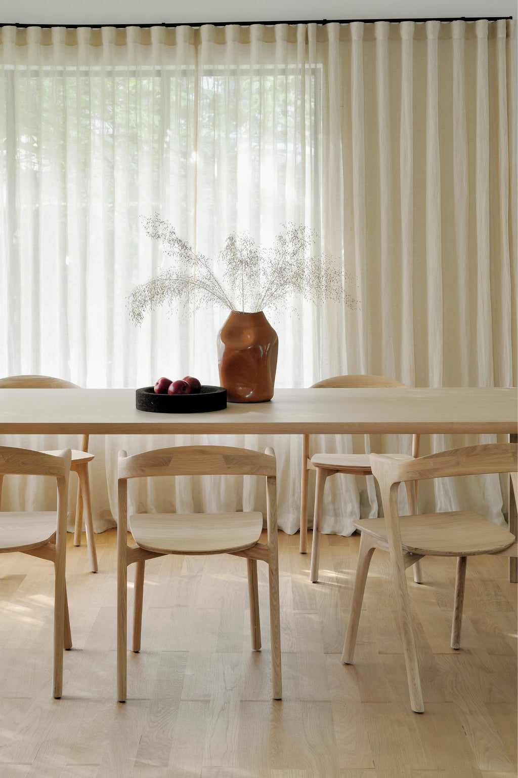 Ethnicraft Air Dining Table, a long rectangular solid wood dining table crafted from light natural oak with a smooth, clean-lined finish and minimalist aesthetic. Its pale wood tone and sleek design embody Scandinavian and modern minimalist styles. This contemporary dining table is perfect for elegant dining rooms or open-plan living spaces.
