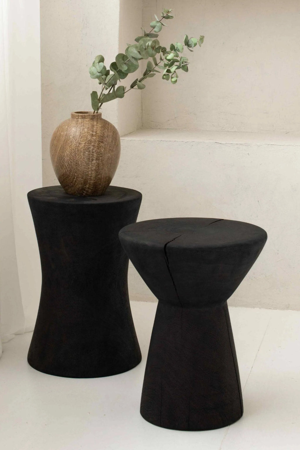 Detjer Stool S.A.S. 002, a pair of sculptural solid wood stools in a deep matte black finish, featuring organic, irregular shapes with visible natural wood.