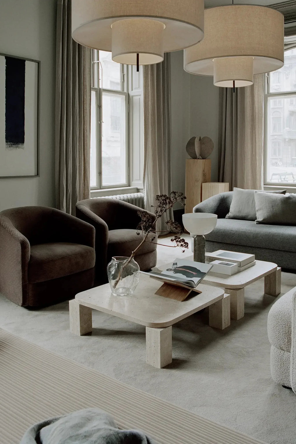 New Works Covent Sofa Deep 3-Seater, a contemporary grey sofa featuring plush, deep seating upholstered in a soft, textured woven fabric. Its minimalist design boasts a gently curved profile and inviting rounded arms, making it an ideal statement piece for modern living rooms and organic minimalist spaces.