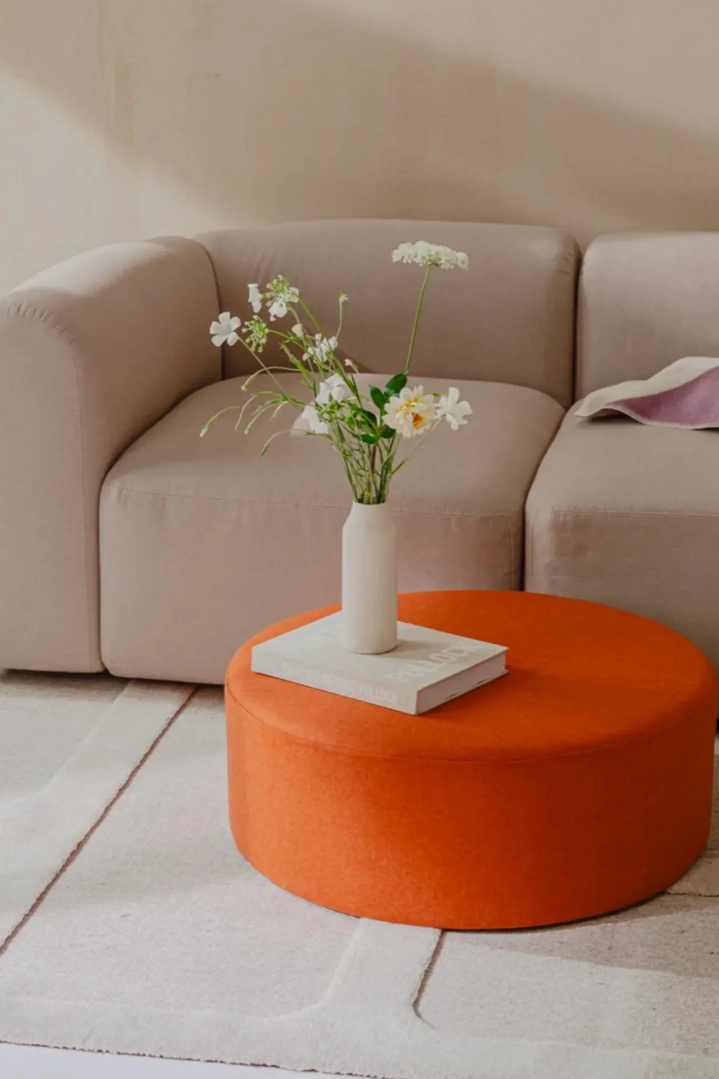 noo.ma Flom 2-Seater Sofa, a contemporary modular sofa upholstered in a soft, light beige textured fabric with a plush, inviting feel and gently curved, armless silhouette. This organic modern design features clean lines, making it an ideal minimalist sofa for small living rooms or a versatile addition to Scandinavian-inspired spaces.