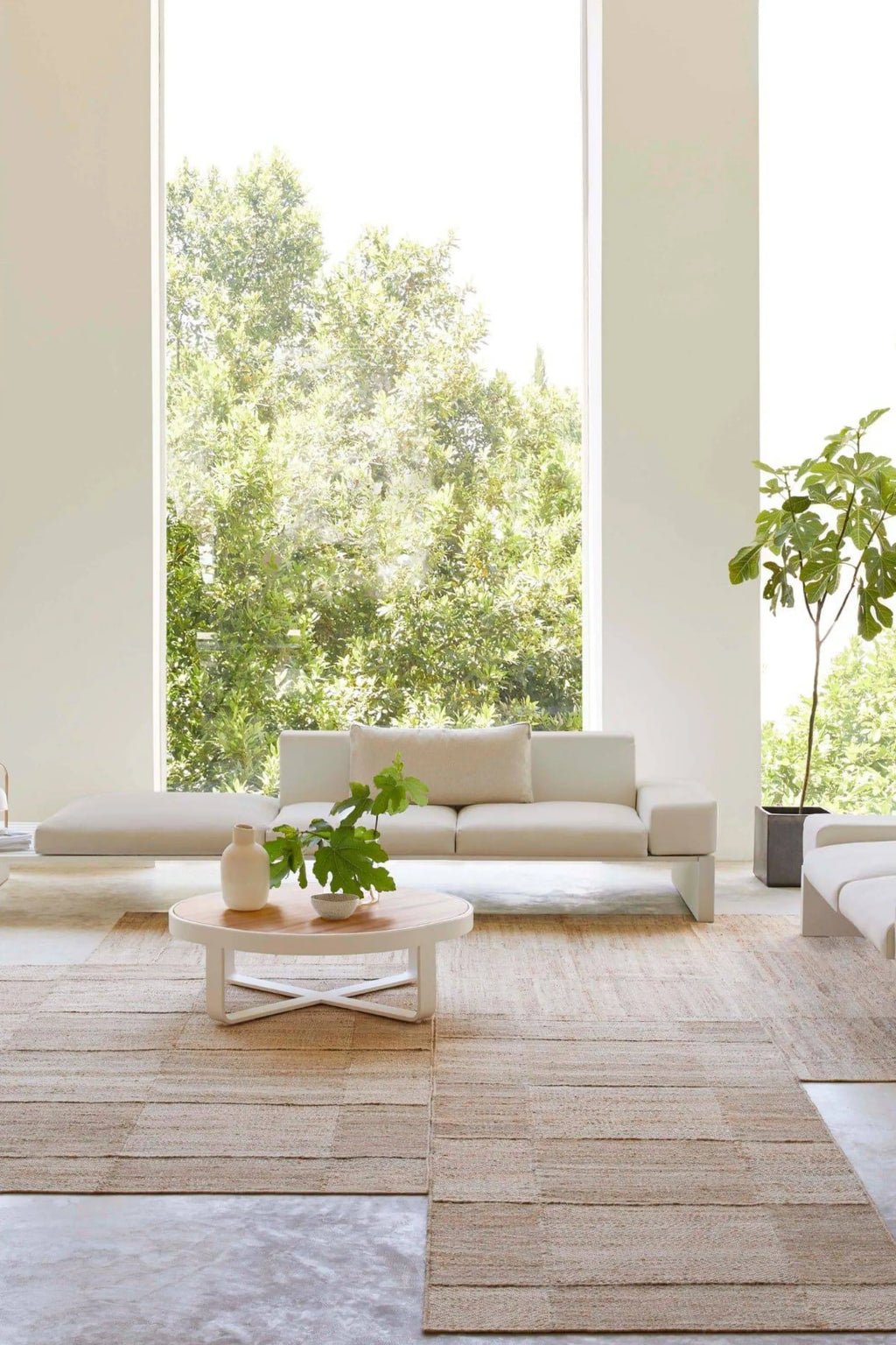 GAN Rugs Roots 02 Rug, a natural hand-woven area rug crafted from raw jute fibers in warm beige and sandy tones, featuring a distinctive textured horizontal stripe pattern. This organic modern rug provides a grounded, inviting feel, perfect for minimalist living rooms, Scandinavian bedrooms, or rustic Mediterranean interiors.