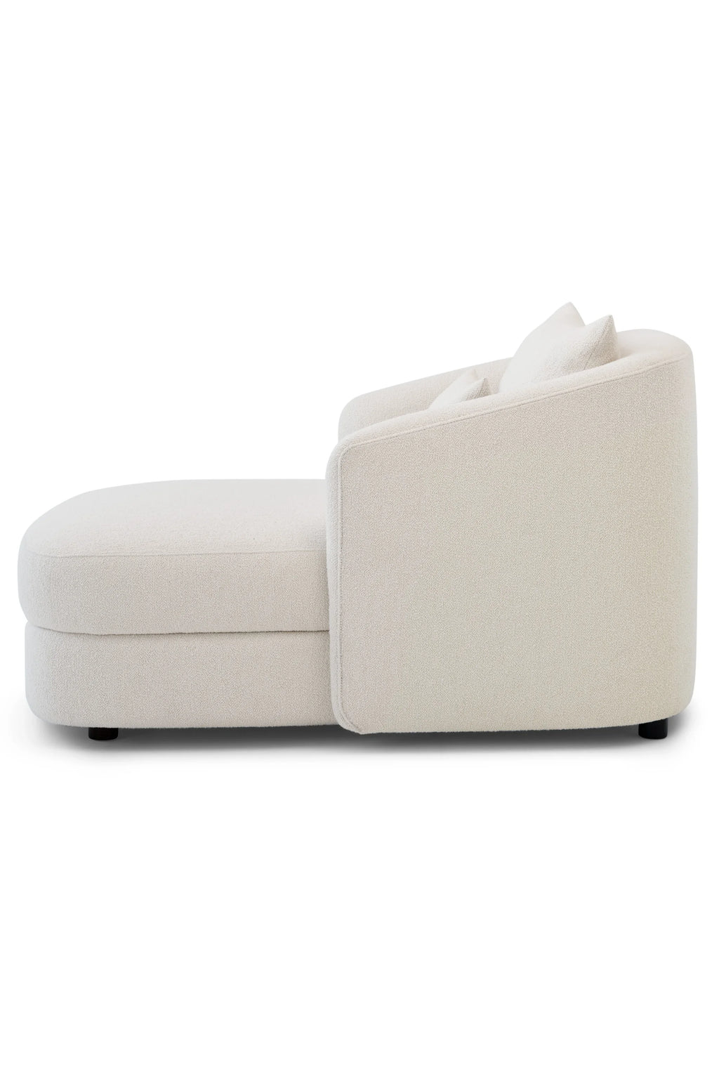New Works Covent Chaise Lounge, a contemporary cream bouclé chaise lounge featuring a plush, textured upholstery and a gracefully curved, organic silhouette. This minimalist and organic modern lounge chair offers deep, comfortable seating and subtle black metal legs, perfect for a sophisticated living room accent or a cozy bedroom reading nook.