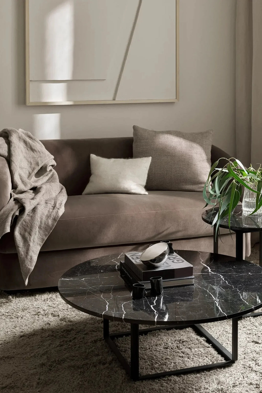 New Works Covent Sofa Narrow 2-Seater, a contemporary 2-seater sofa upholstered in plush taupe fabric with a gently curved, inviting silhouette and deep seating, featuring a minimalist design. This compact sofa is perfect for small living rooms, apartments, or cozy modern spaces, offering a blend of organic modern style and comfort.